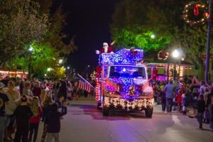 A lighted up truck with Santa on top in the downtown Brenham Christmas parade.