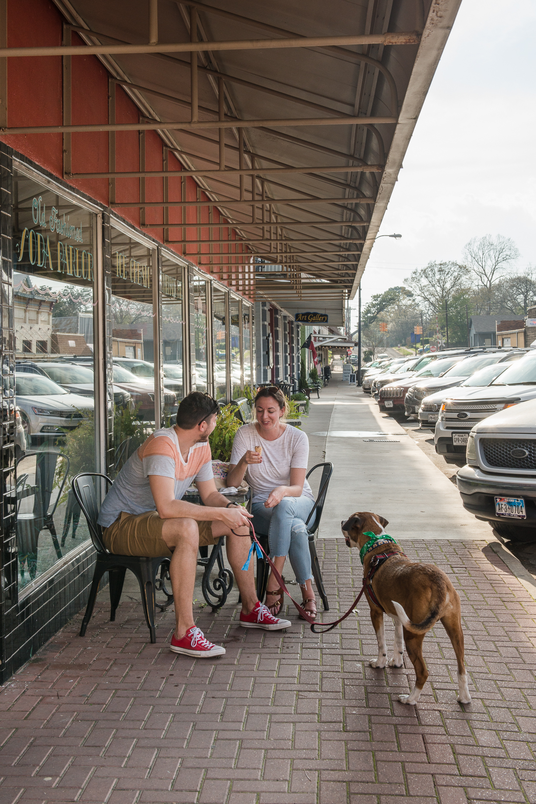 A couple sitting on the porch of Must Be Heaven with their dog.