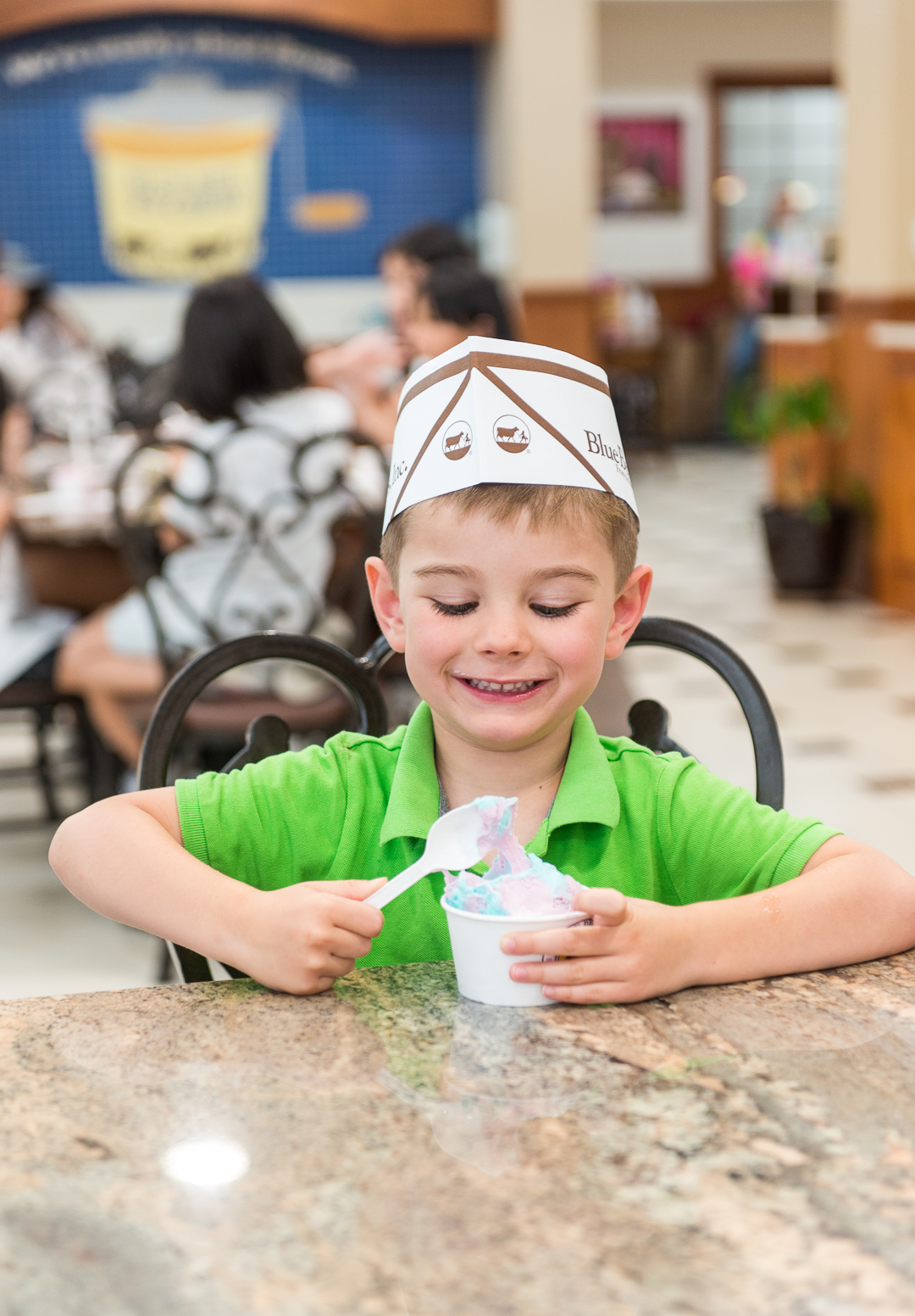 young boy eating ice cream and smiling at Blue Bell Creameries