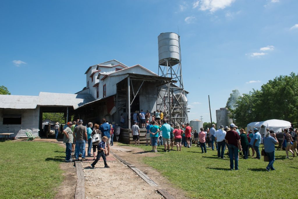The Burton Cotton Gin with a large group of people standing in front of it.