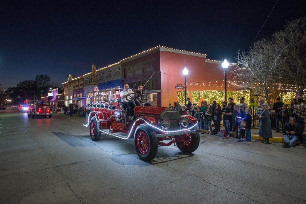 Old firetruck lit up during Christmas Parade in Downtown Brenham