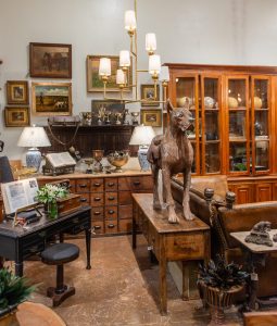 The inside of an antique store. In the center there is a large dog statue on top of a table. Photo by Natalie Lacy Lange