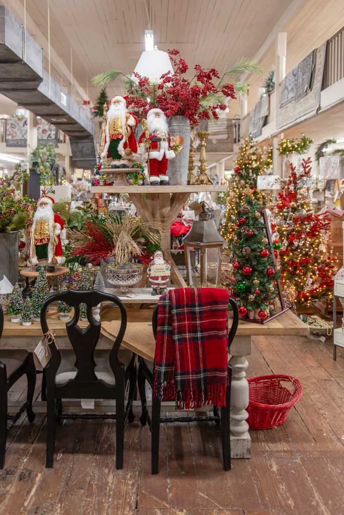 The inside of a furniture store. The center table is covered in colorful Christmas decorations.