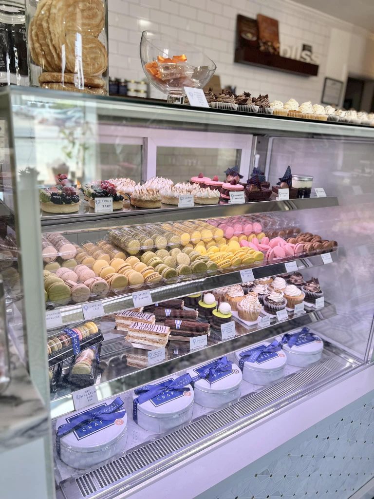 Many pastries and macaroons in a display case at Thomas Craft.