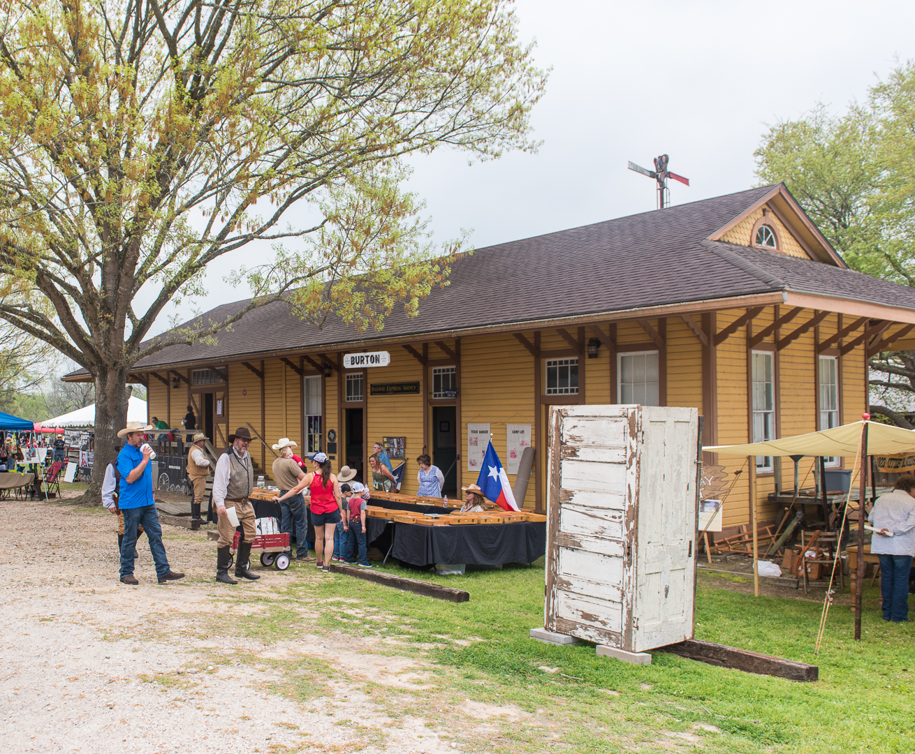 Yellow train depo in Burton with tables set out in front of it. Families are looking at the displays on the tables.