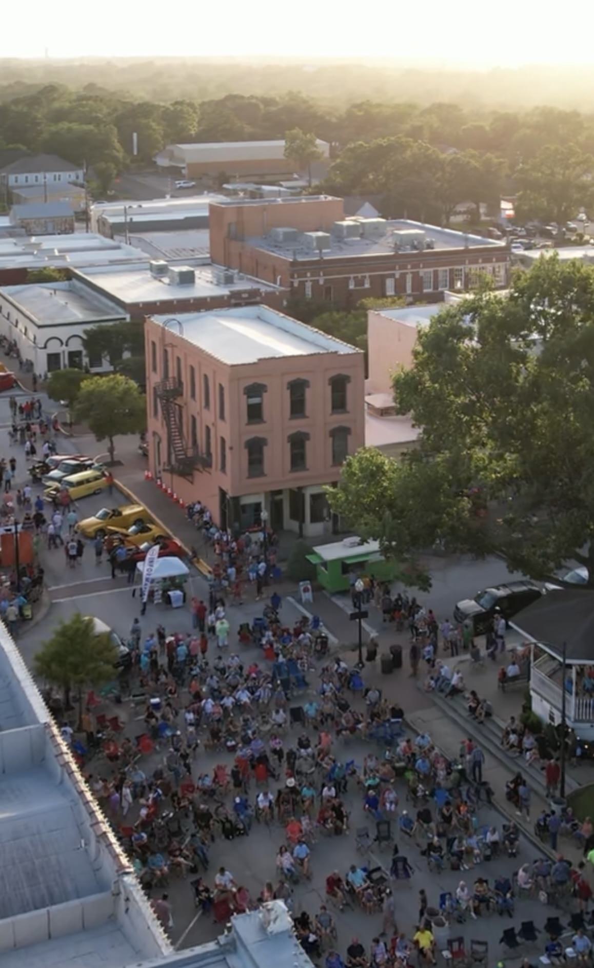Aerial photo of large crowd attending summer concert series, Hot Nights Cool Tunes, in Downtown Brenham. Photo by Natalie Lacy Lange