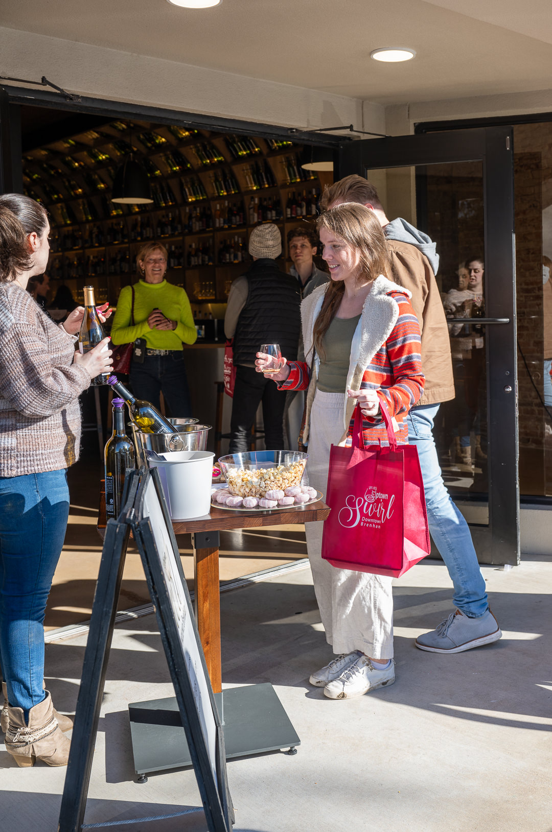 Uptown Swirl participants enjoy wine samples and snacks at Haak Winery on a sunny day in Downtown Brenham.