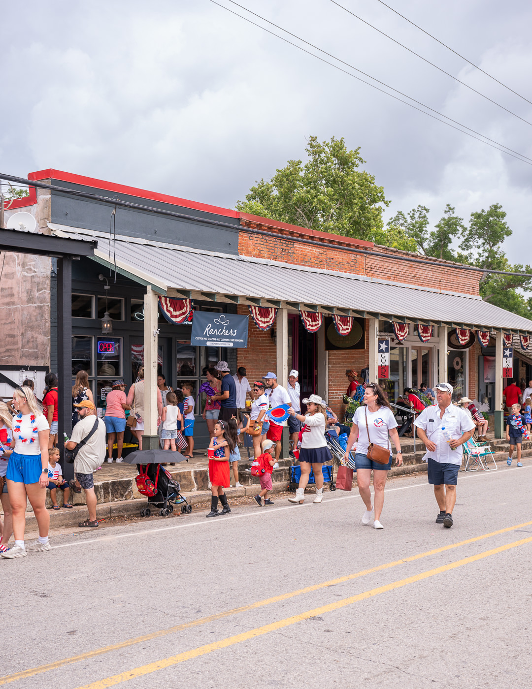people gather in front of businesses following the Chappell Hill Independence Day Parade