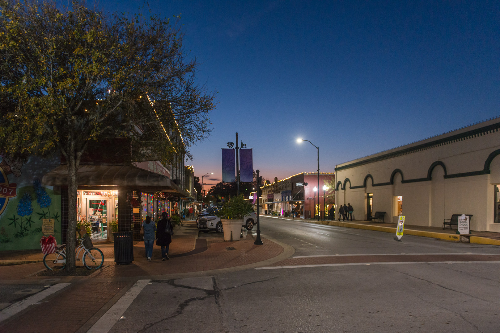 Dusk in historic Downtown Brenham-- ladies walking between shops.